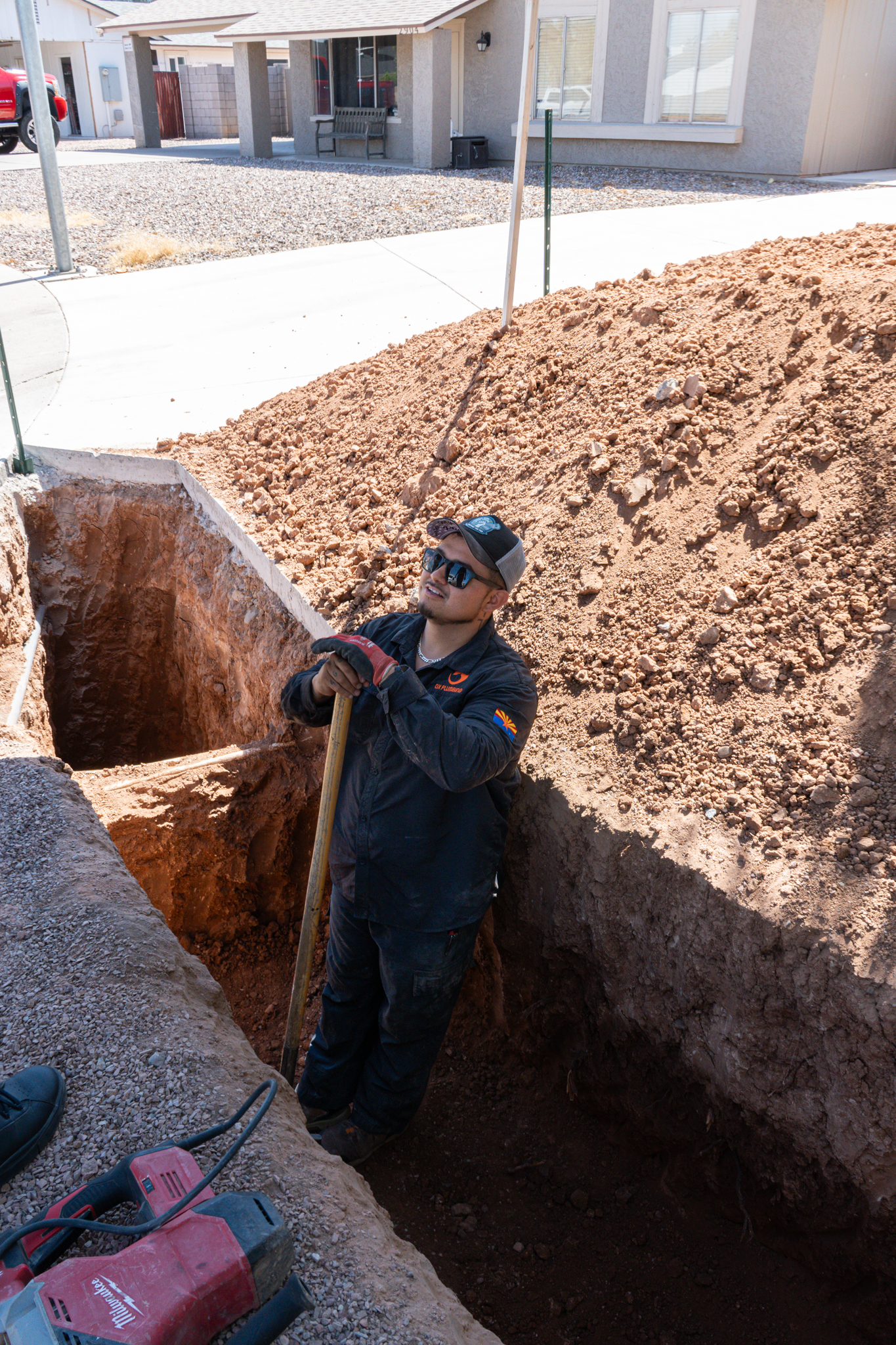 OX Plumbing worker in a ditch for a front drain replacement