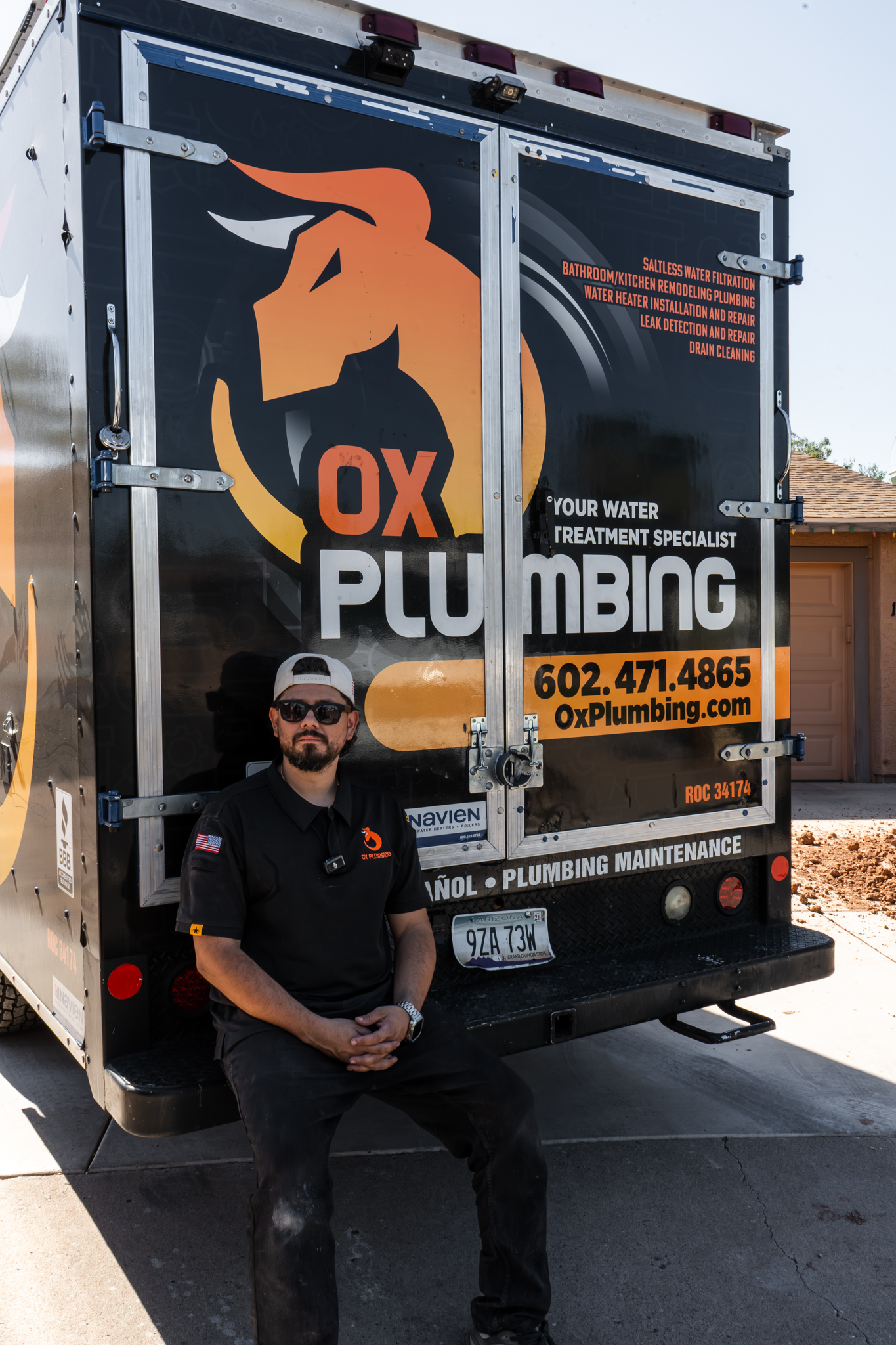 Erik, owner of OX Plumbing, sitting in front of the wrapped van
