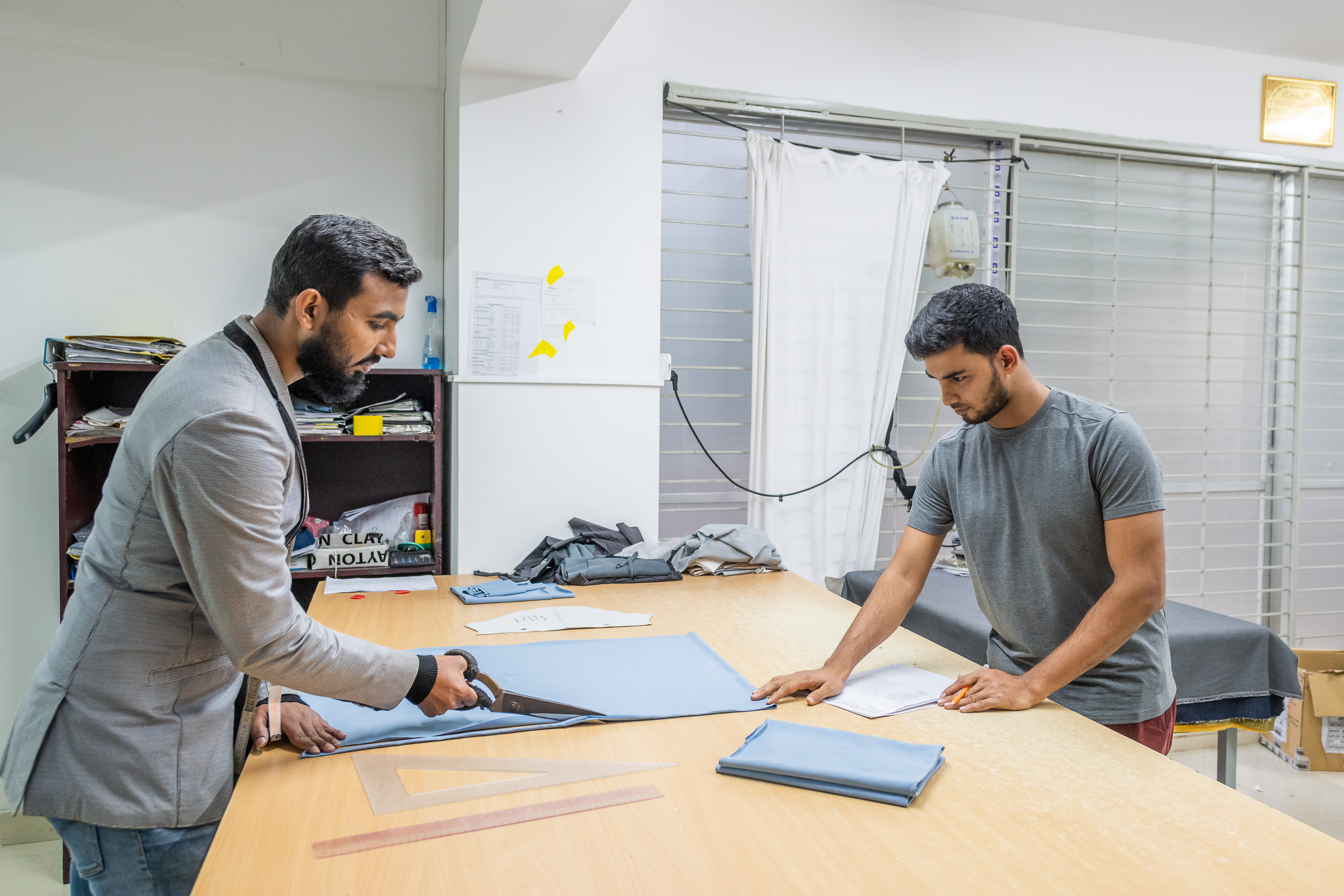 HRM team reviewing fabric and sample details at a Dhaka worktable