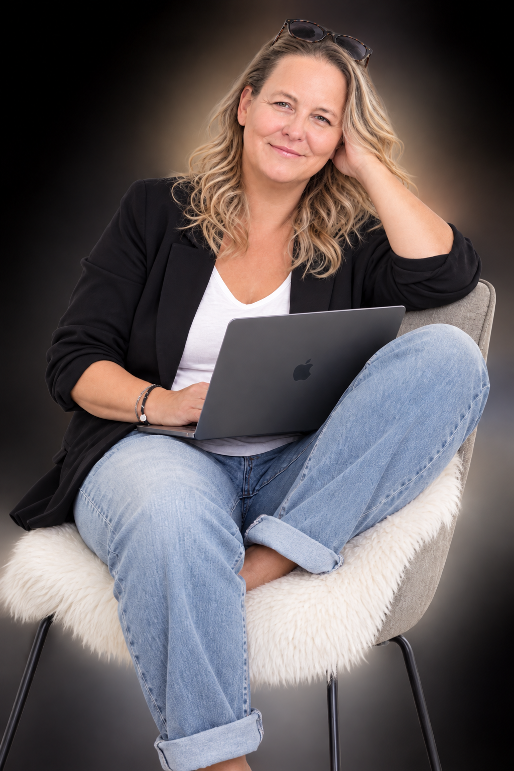Sonja Hils sitzt im Sessel mit Laptop