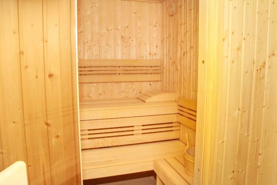 Custom sauna interior with wood walls and multi-level benches