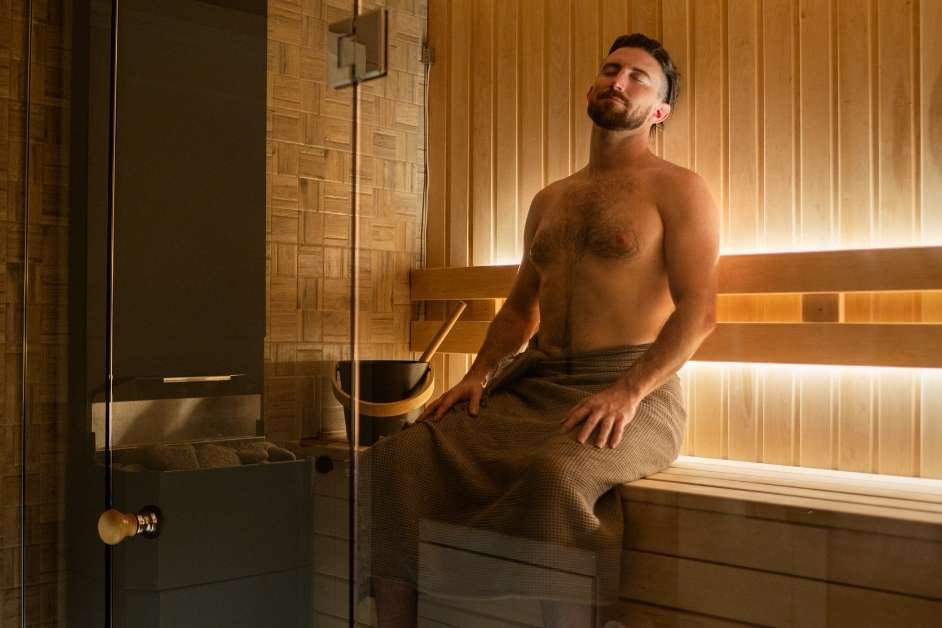 Custom wood sauna with bench seating and sauna heater