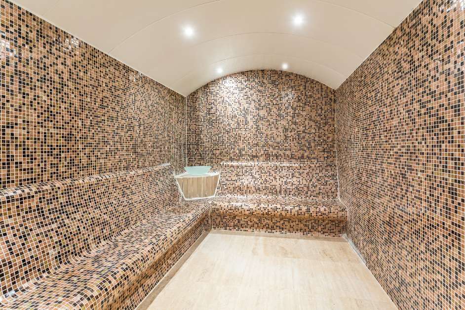 Steam room with tiled walls and seating