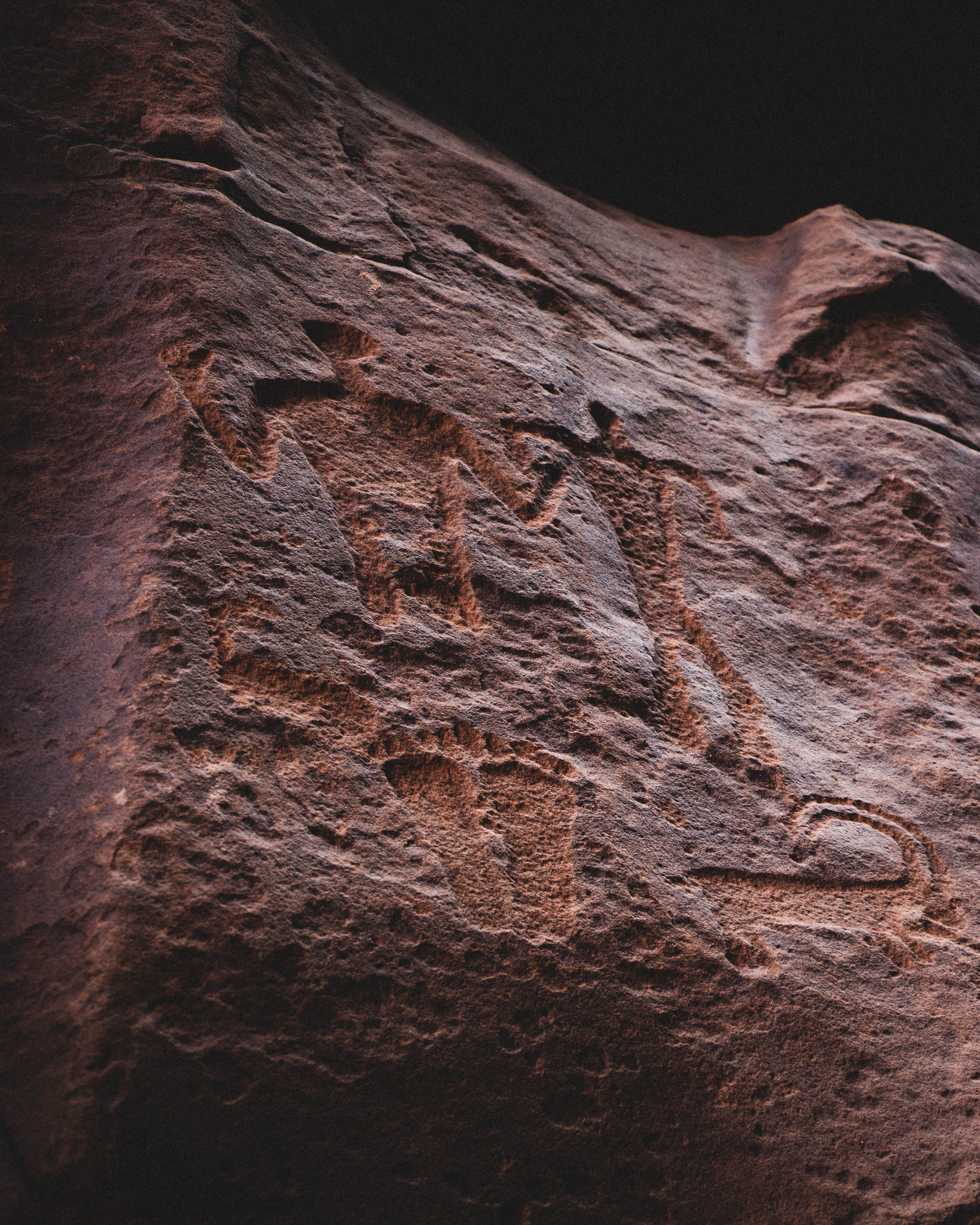 image shows two people and footprints carved into a cave wall - reminiscent of cave drawings image shows two people and footprints carved into a cave wall - reminiscent of cave drawings