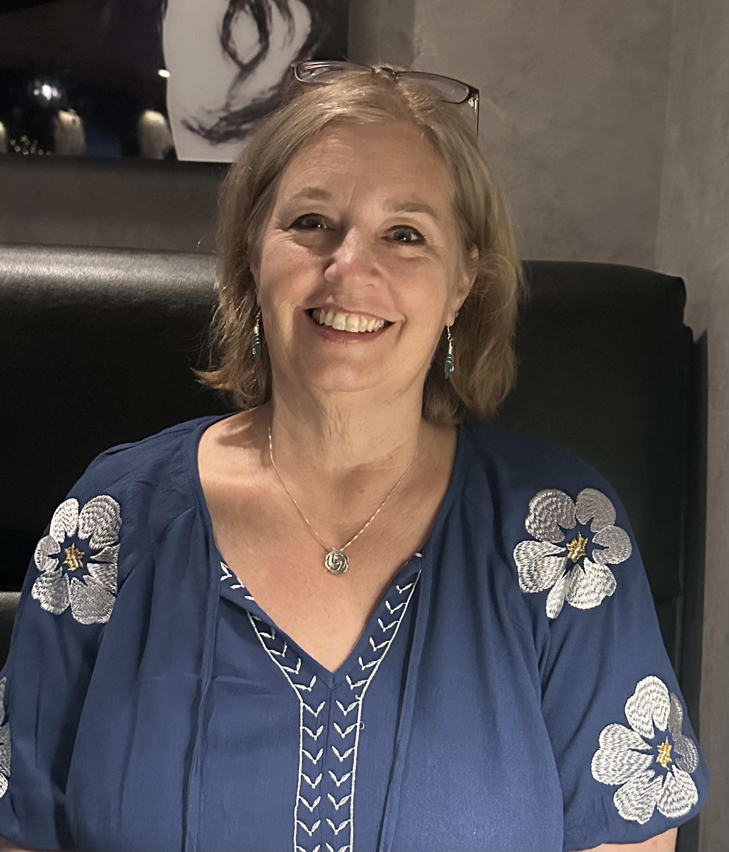 Smiling woman enjoying nature outdoors, representing personal transformation and well-being through hypnotherapy and mental wellness.