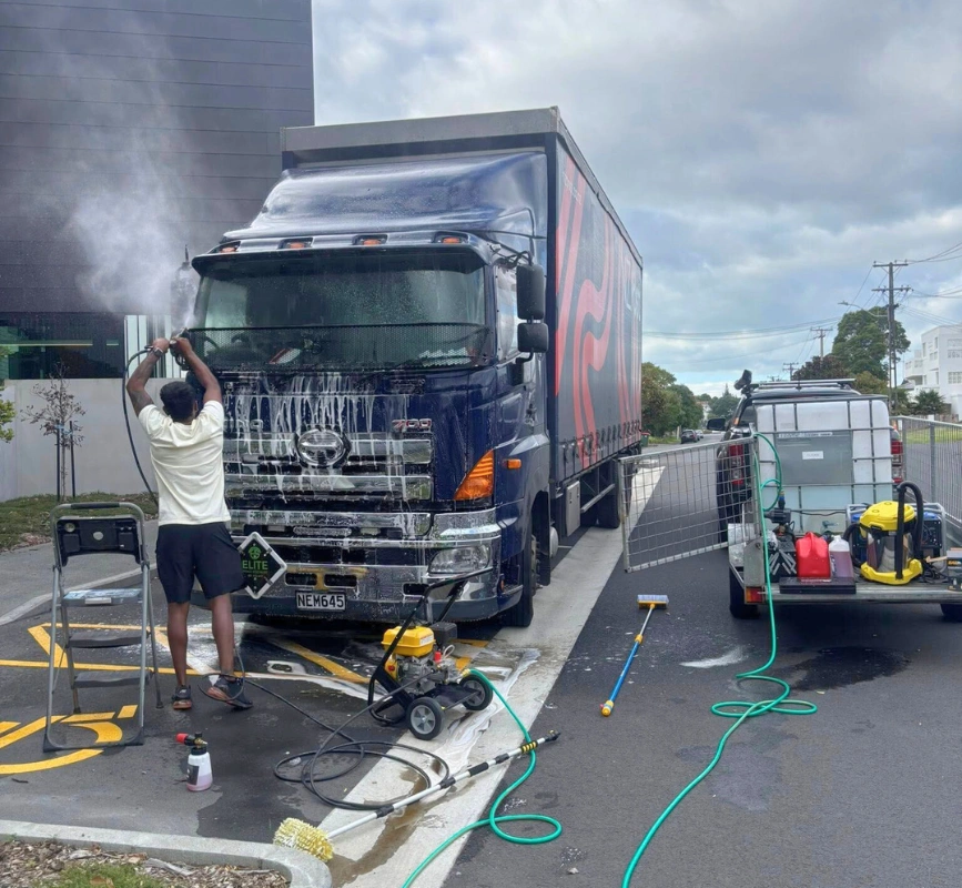 Hard and Fast Detailing team pressure washing a large commercial truck in Auckland