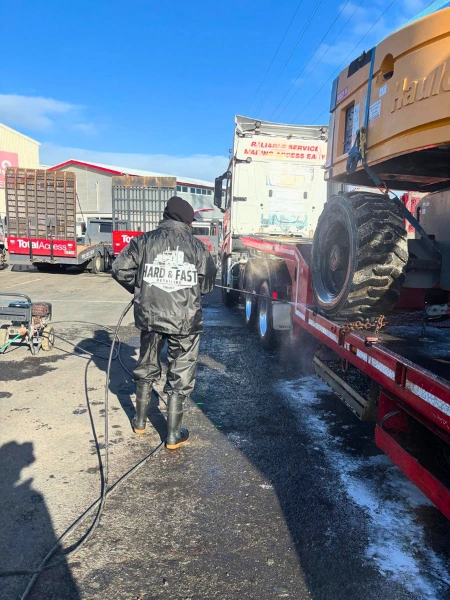 Hard and Fast Detailing staff using high-pressure water jet on truck chassis