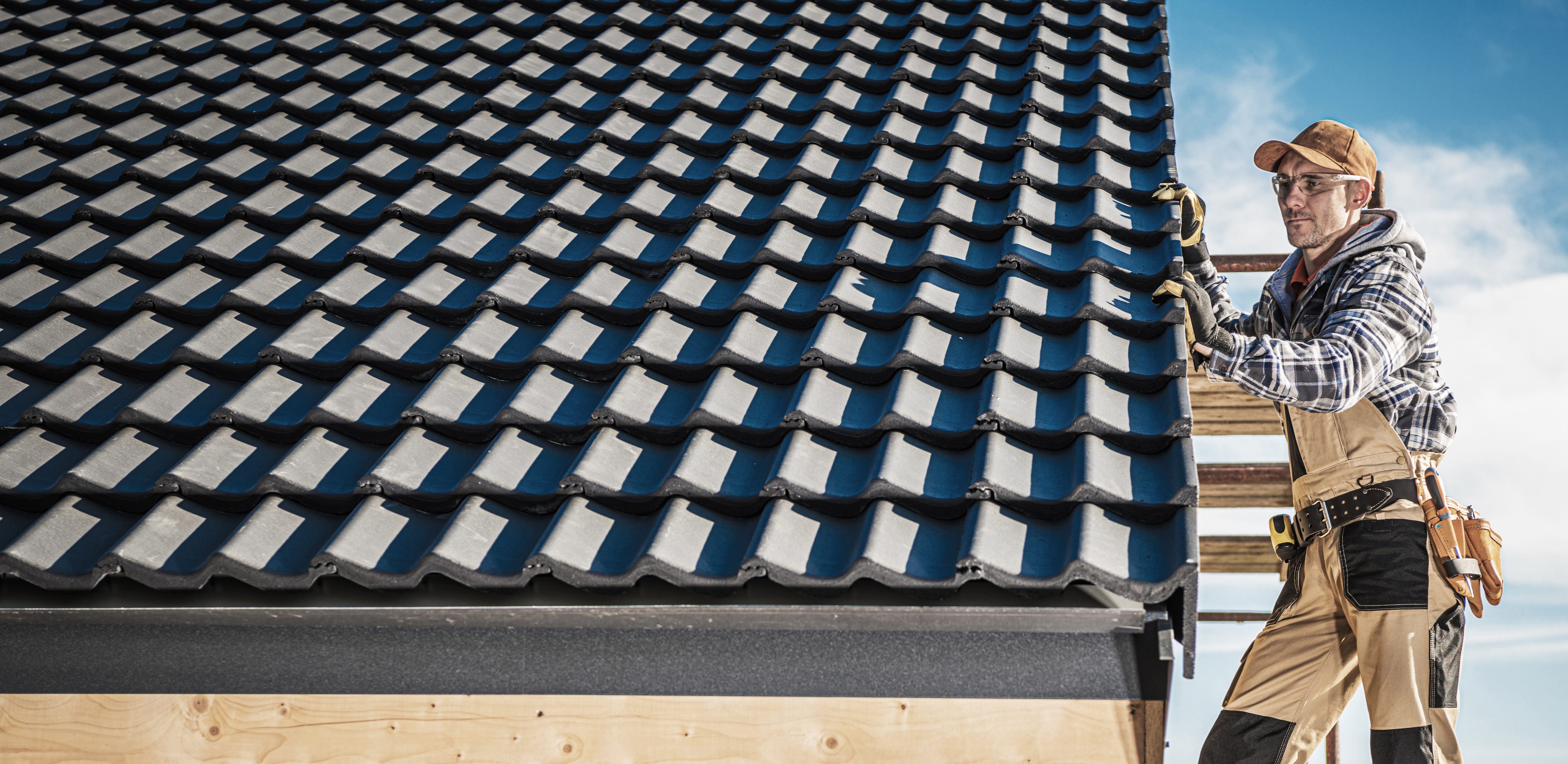 Roofer installing tiles on a new roof