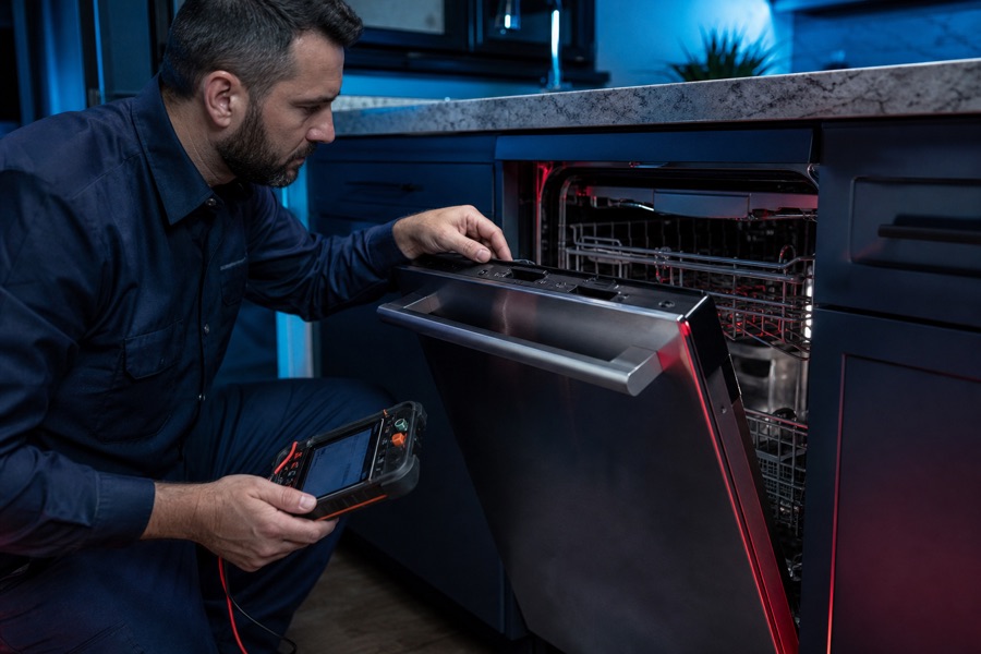 Technician checking dishwasher controls and door latch