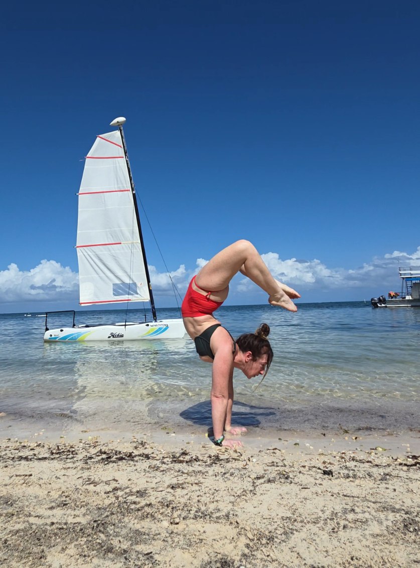 Kristen performing handstand by a boat
