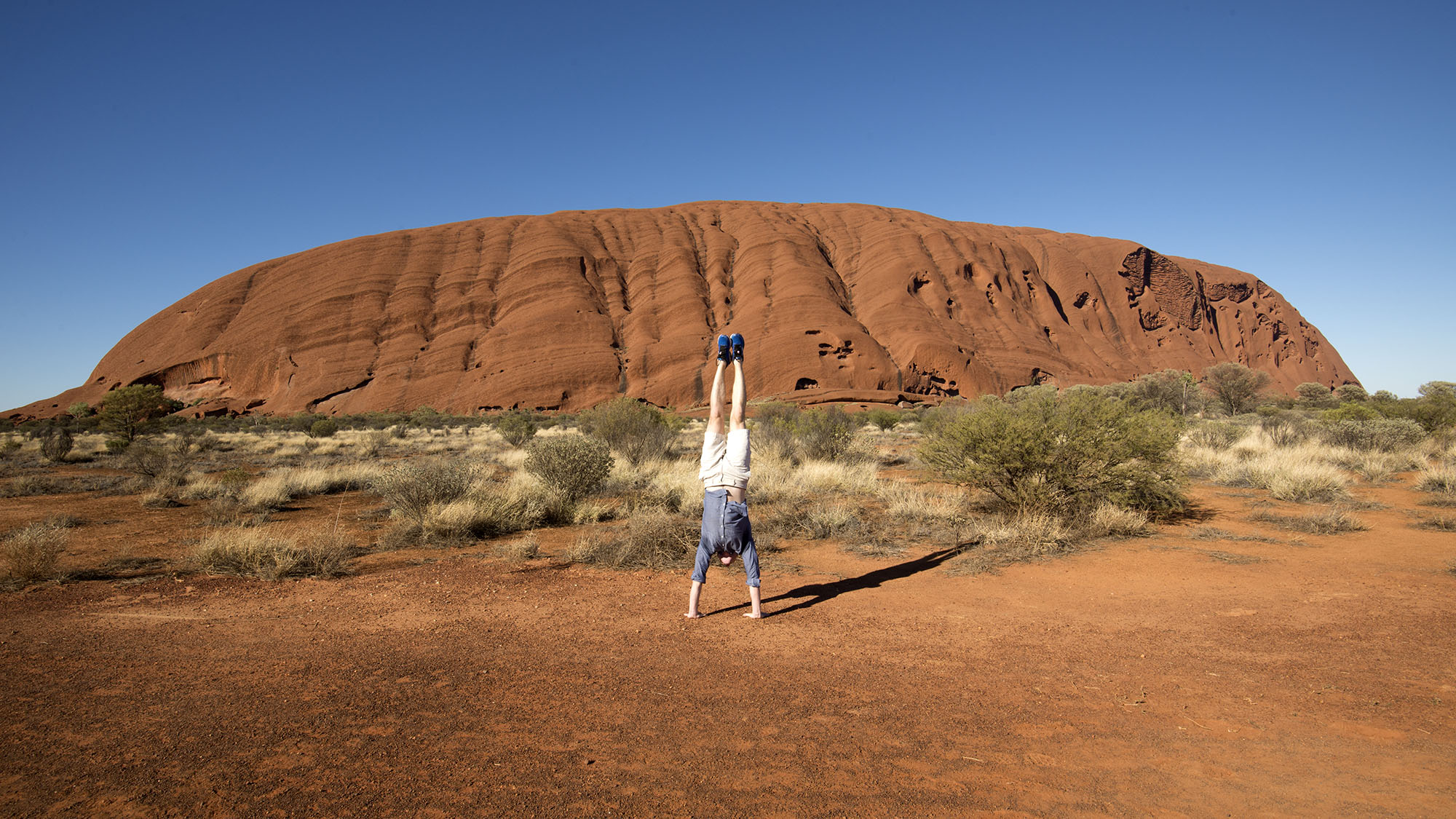 Peter performing handstand on desert mound