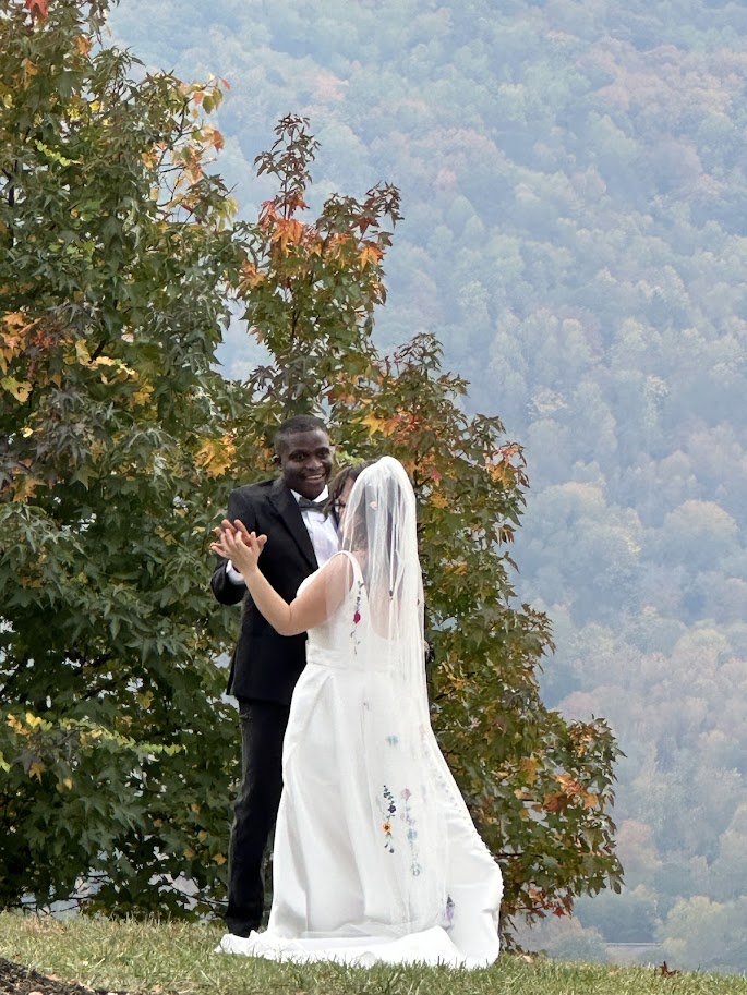 Bride and groom sharing a moment in front of fall trees