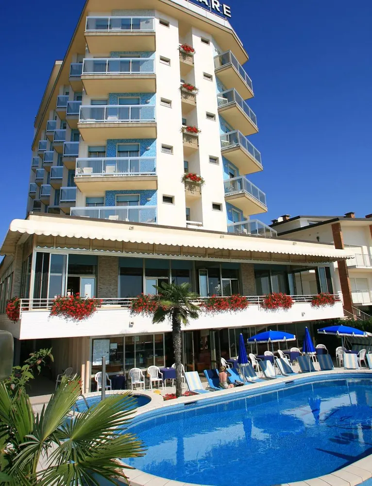 La facciata dell'hotel con la piscina davanti