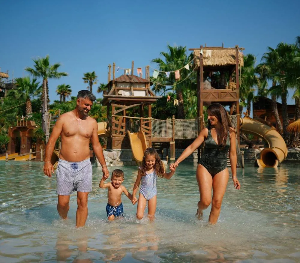 Una famiglia con due bambine nell'acqua del parco Caribe Bay