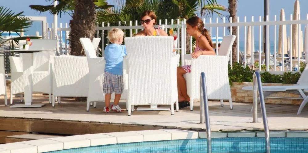 Una famiglia a tavola sulla terrazza vicino alla piscina