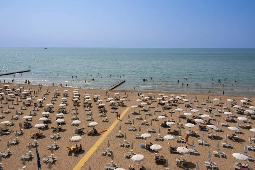 Gli ombrelloni in fila sulla spiaggia riservata dell'hotel