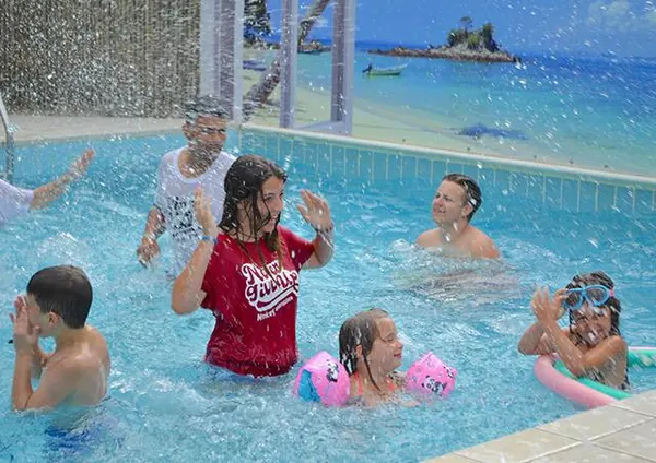 Bambini e genitori che giocano in piscina