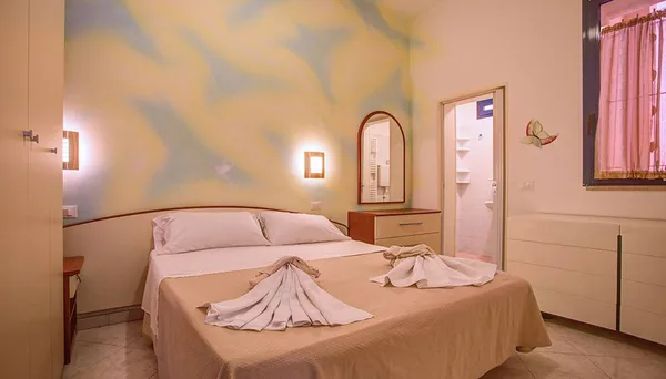 Camera matrimoniale dell'appartamento con gli asciugamani piegati sul letto
