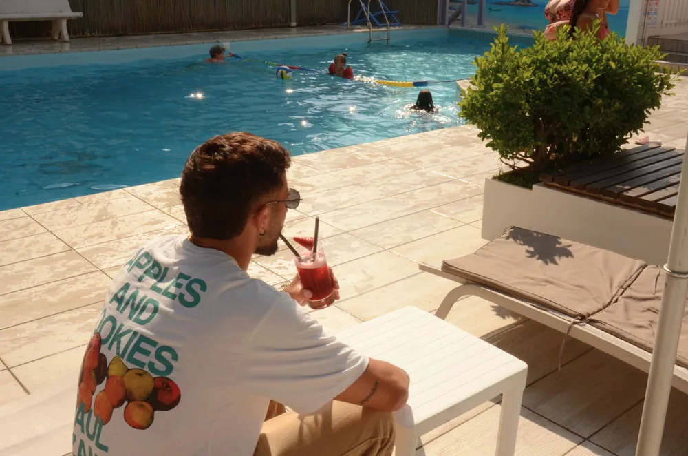 Bordo piscina con un ospite che si gode una bibita
