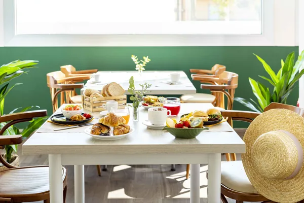 Tavolo della colazione con brioche, frutta e spremute