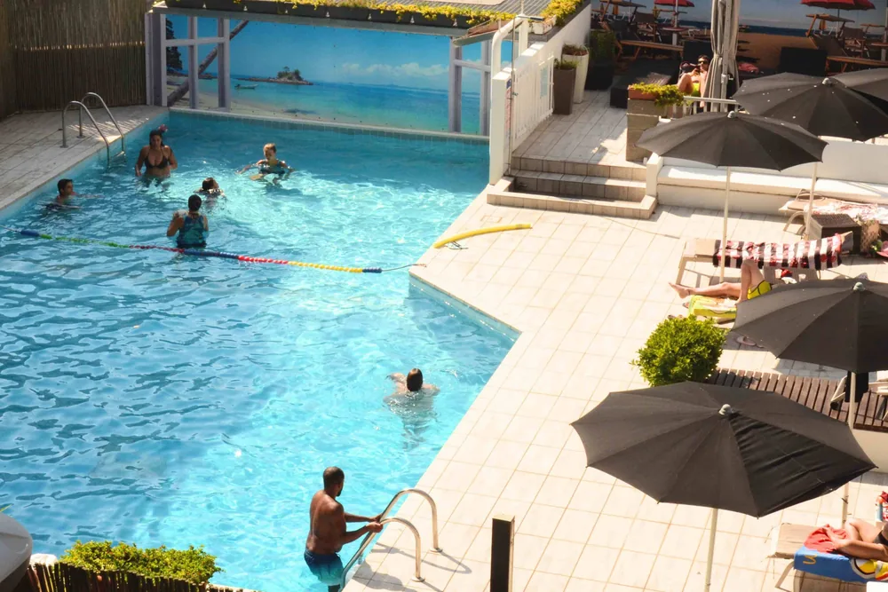La piscina dell'Eurhotel vista dall'alto, con gli ombrelloni e una famiglia in acqua