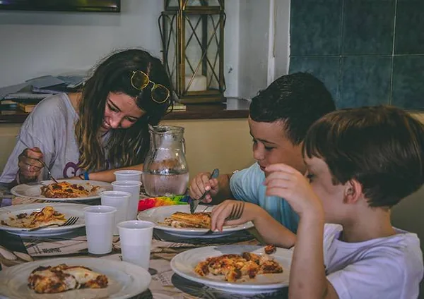 Bambini a tavola con la pizza