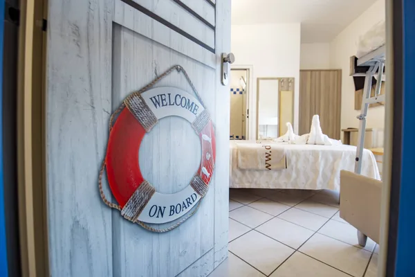 La porta di una camera con il salvagente "Welcome on board"