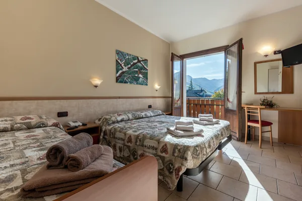 Camera luminosa con letto matrimoniale, letto singolo e portafinestra
