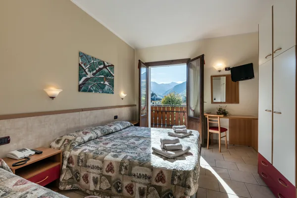 Camera con letto matrimoniale e balcone aperto sui monti