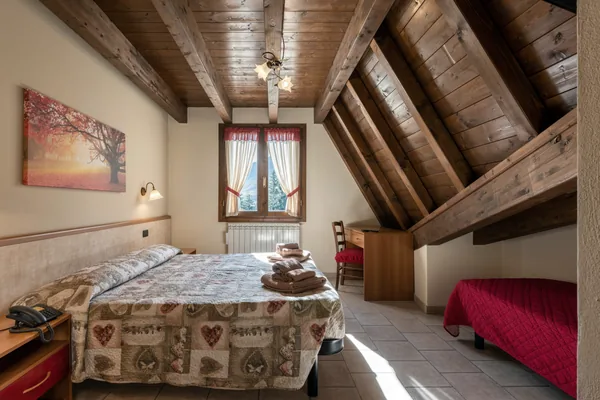 Camera nel sottotetto con le travi di legno a vista