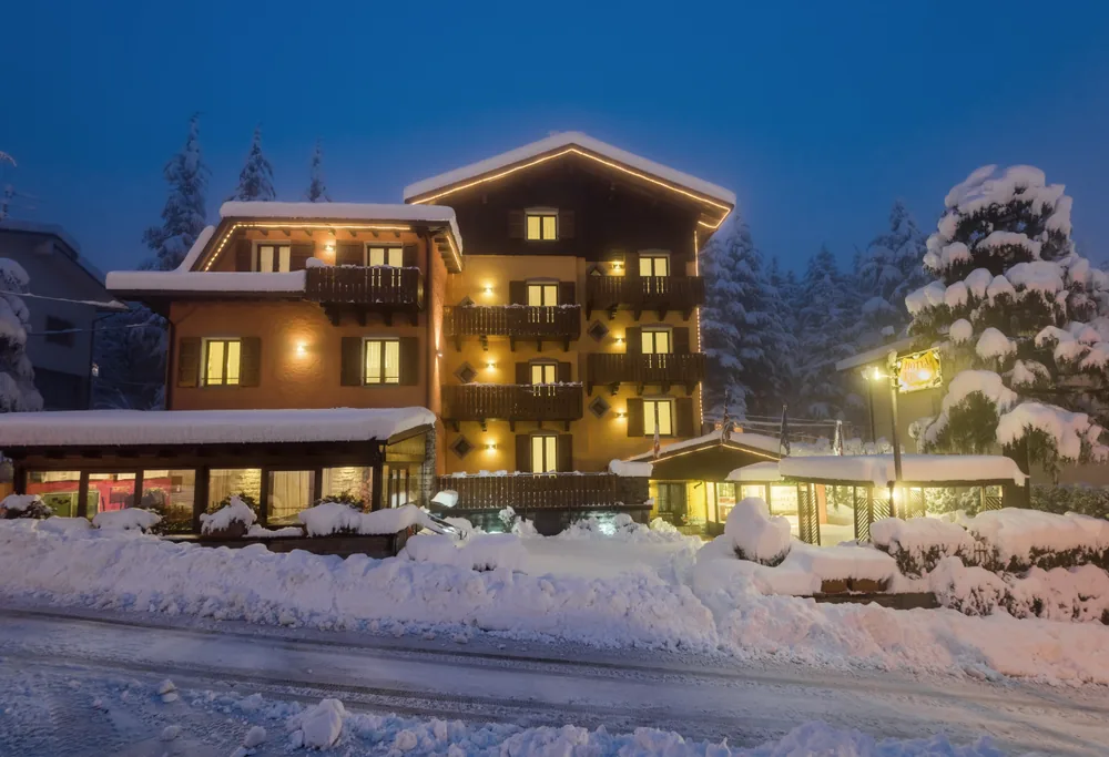 L'Hotel Pineta di sera sotto la neve, con le luci accese