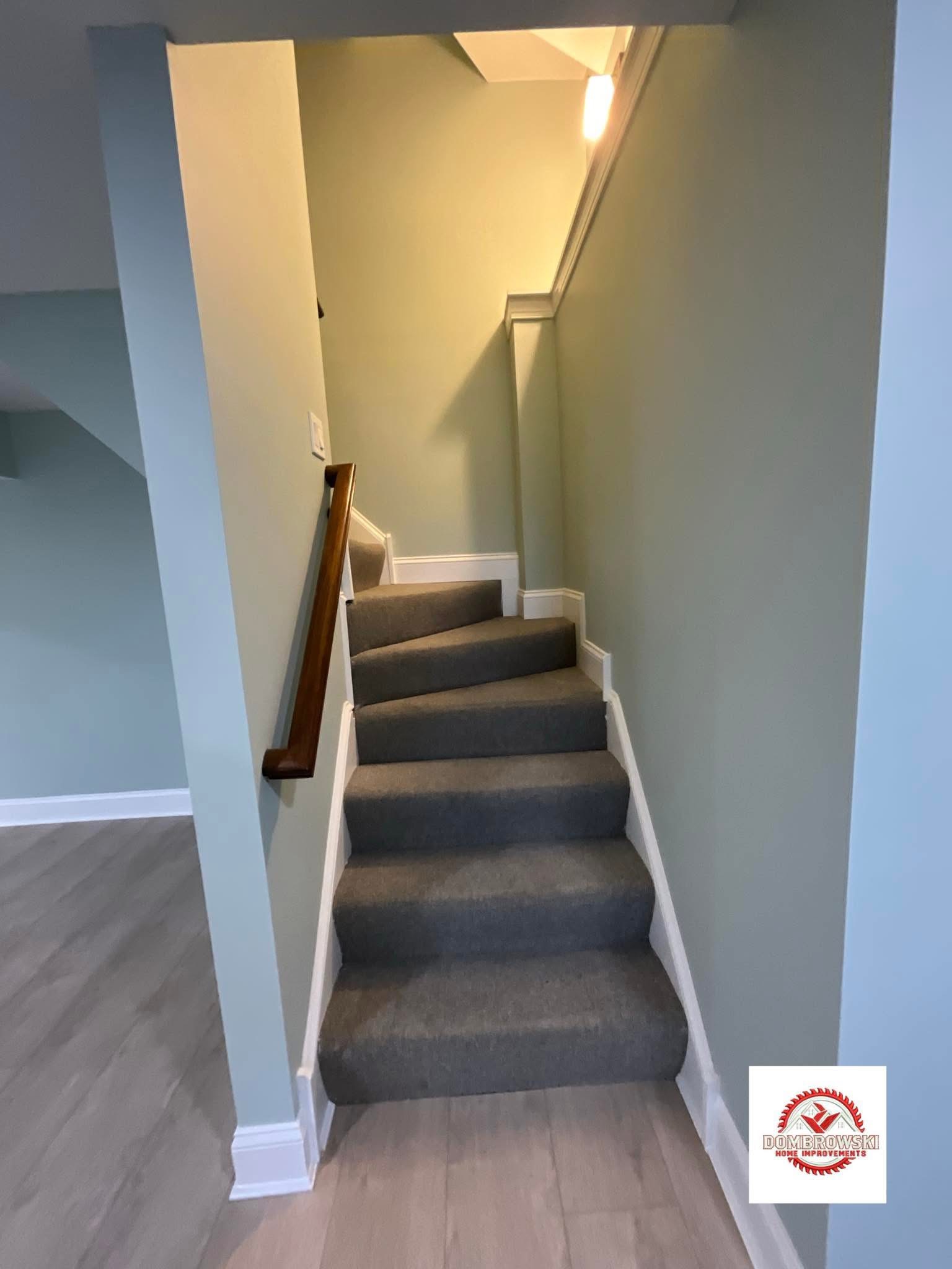 Finished basement with sage green walls and carpeted staircase in Bucks County, PA by Dombrowski Home Improvements