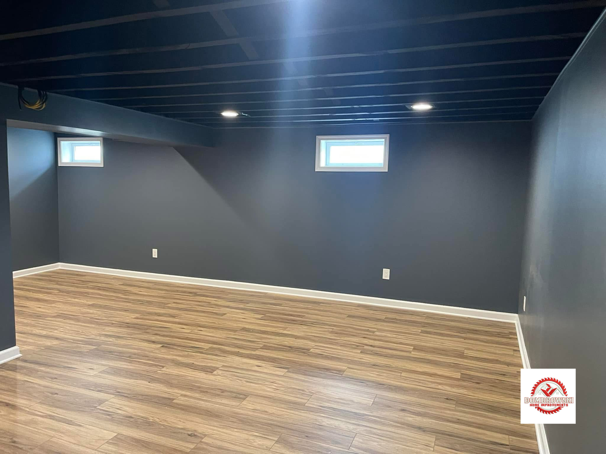 Finished basement with navy walls and open painted ceiling in Bucks County, PA by Dombrowski Home Improvements