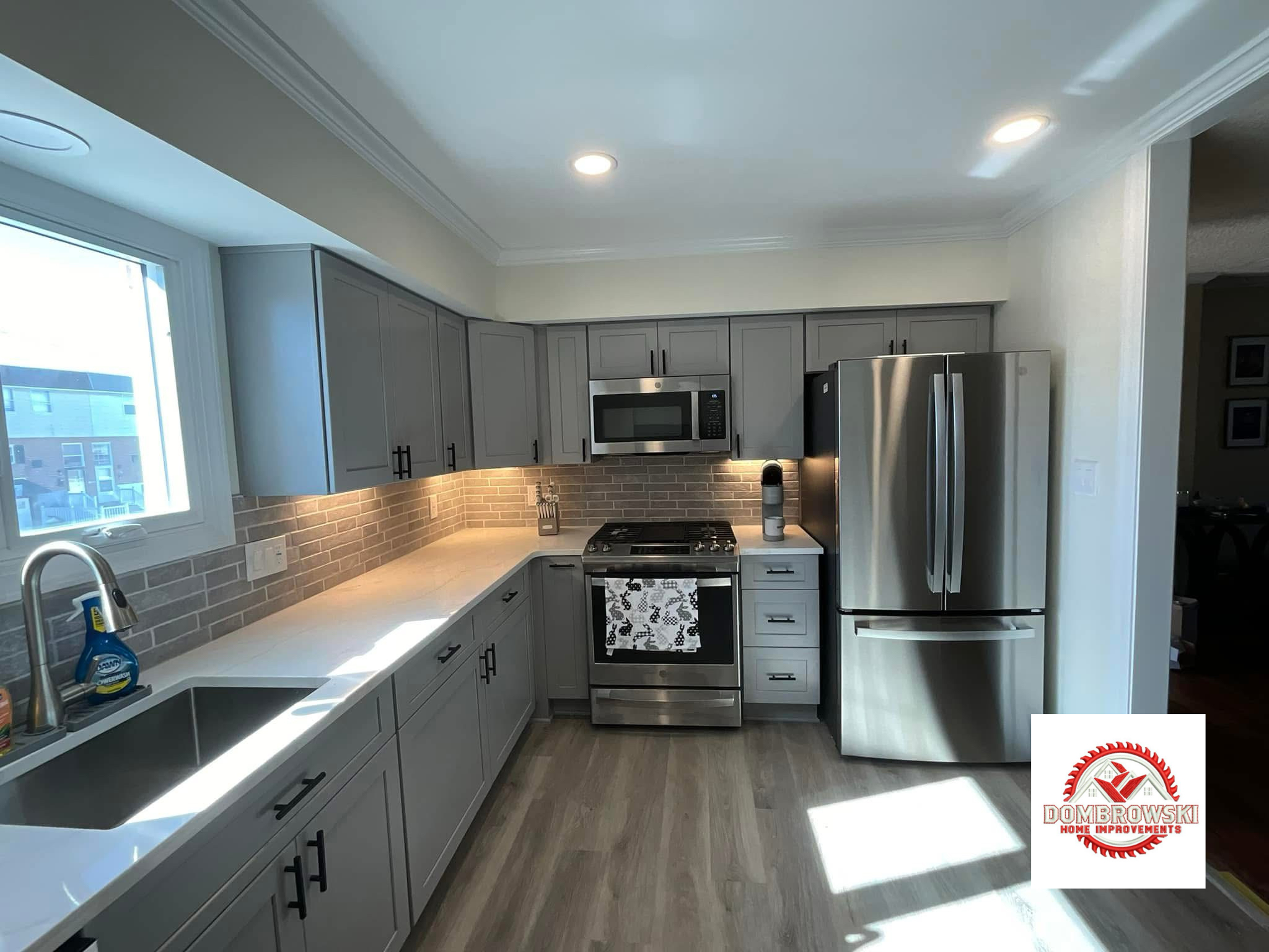 Stove and refrigerator area: gray shaker cabinets with under-cabinet lighting