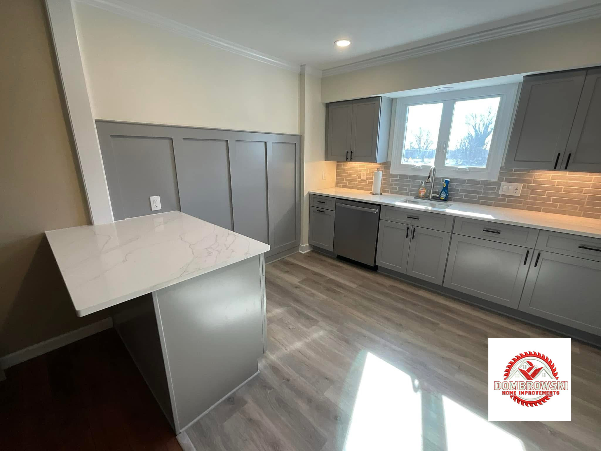 Kitchen island and wall view: quartz countertop and brick backsplash detail