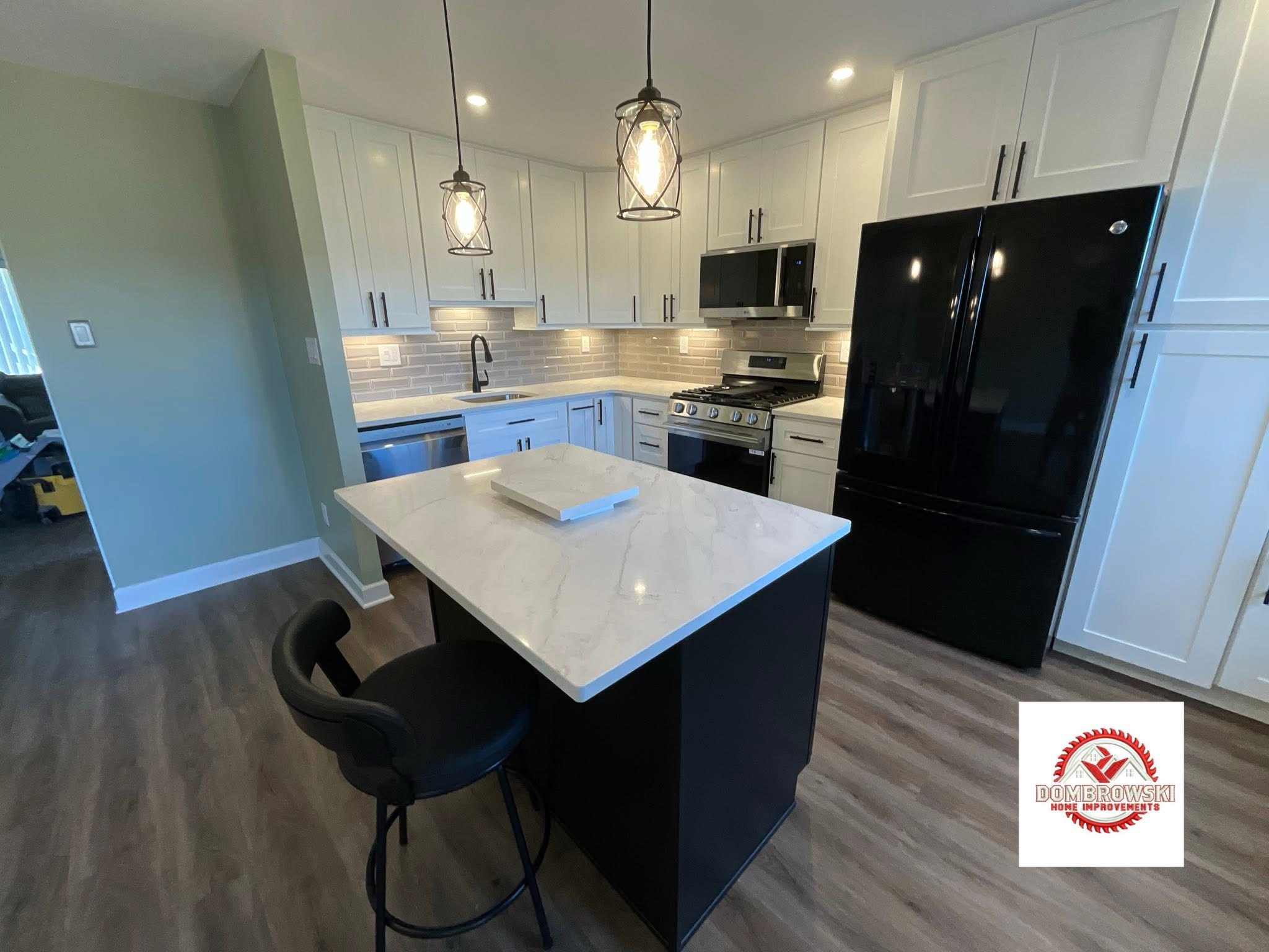 White shaker kitchen cabinets with black island, quartz countertop and pendant lights, Dombrowski kitchen remodeling Bucks County