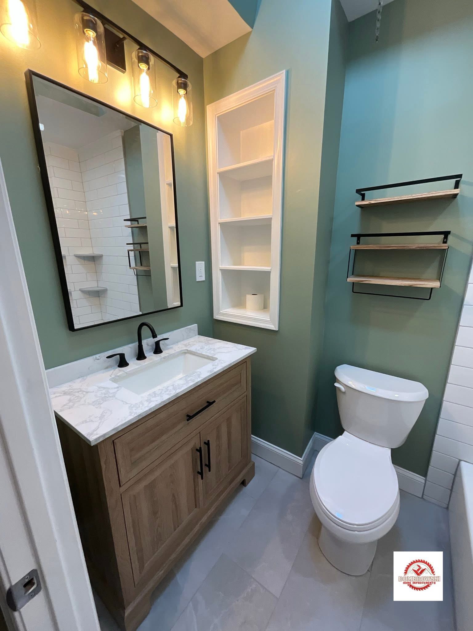Sage green bathroom with natural wood vanity, quartz countertop and white subway tub surround