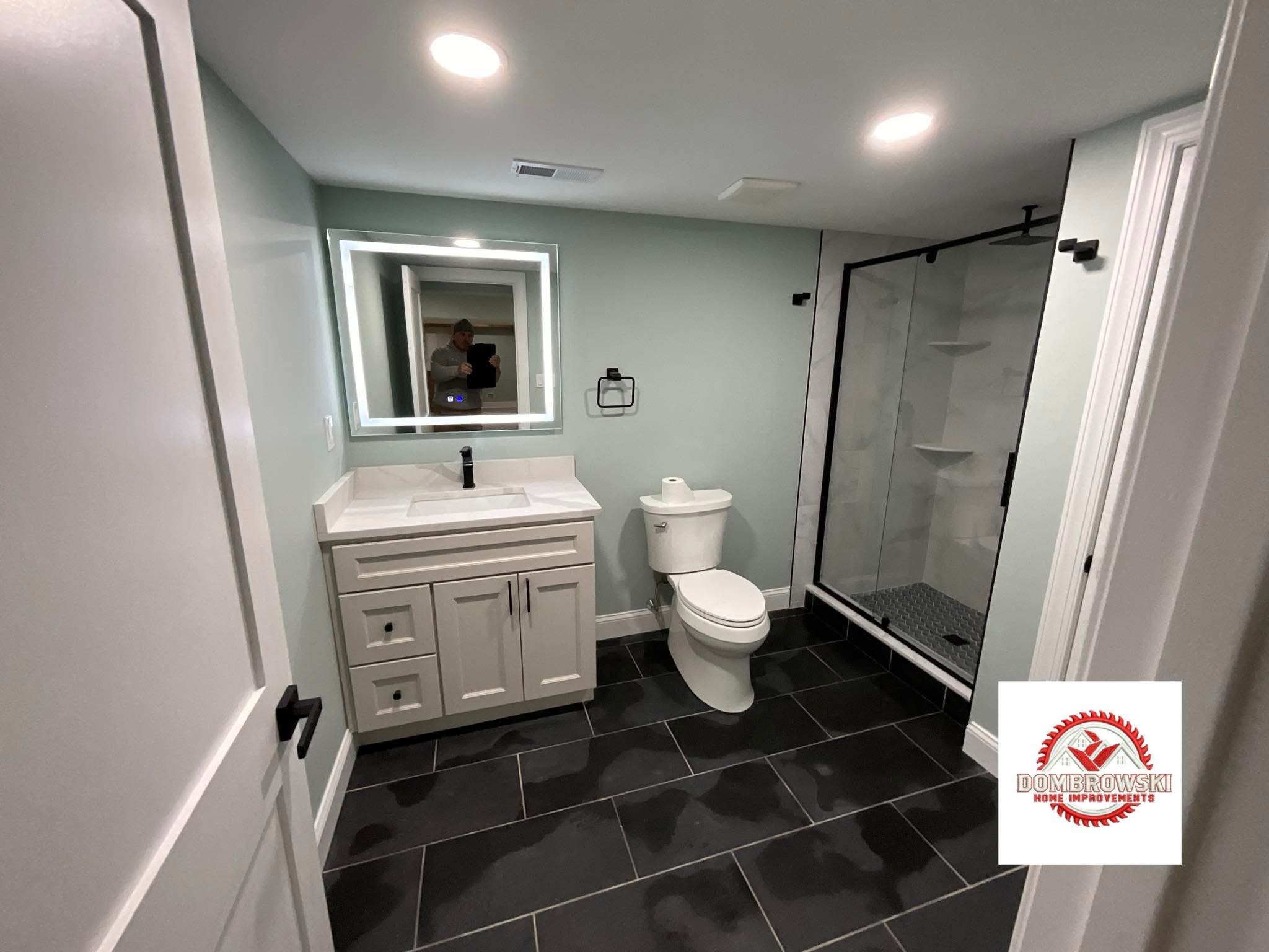 Full bathroom view: walk-in glass shower, gray floor tile and neutral walls