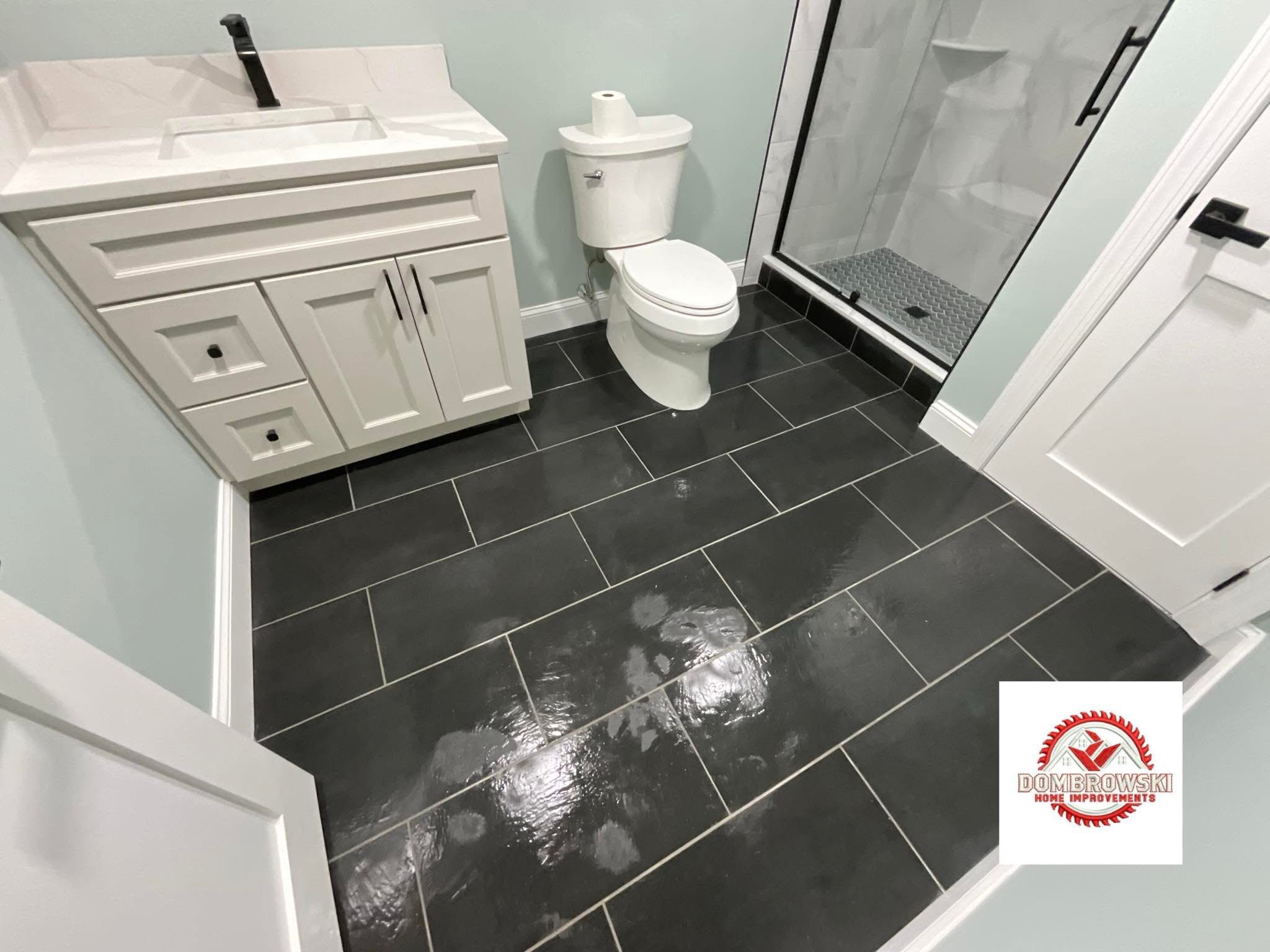 Gray large format tile floor with walk-in shower and white vanity