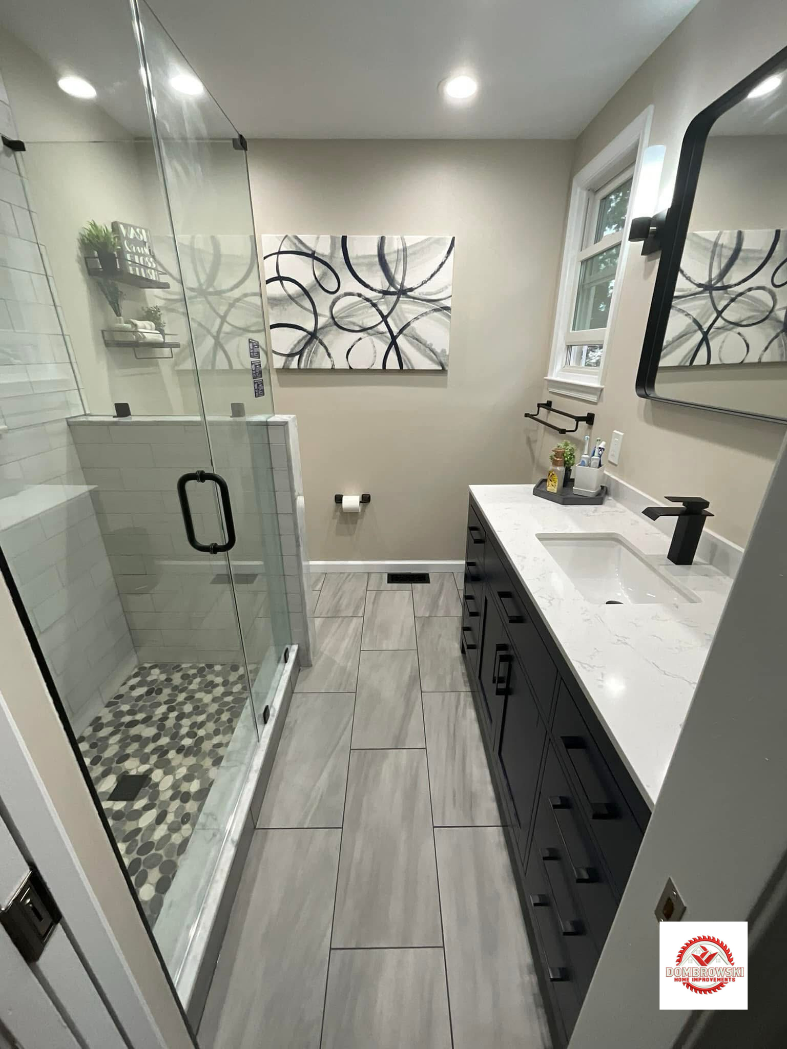 Black vanity with quartz top and walk-in glass shower, Dombrowski bathroom remodeling Bucks County PA