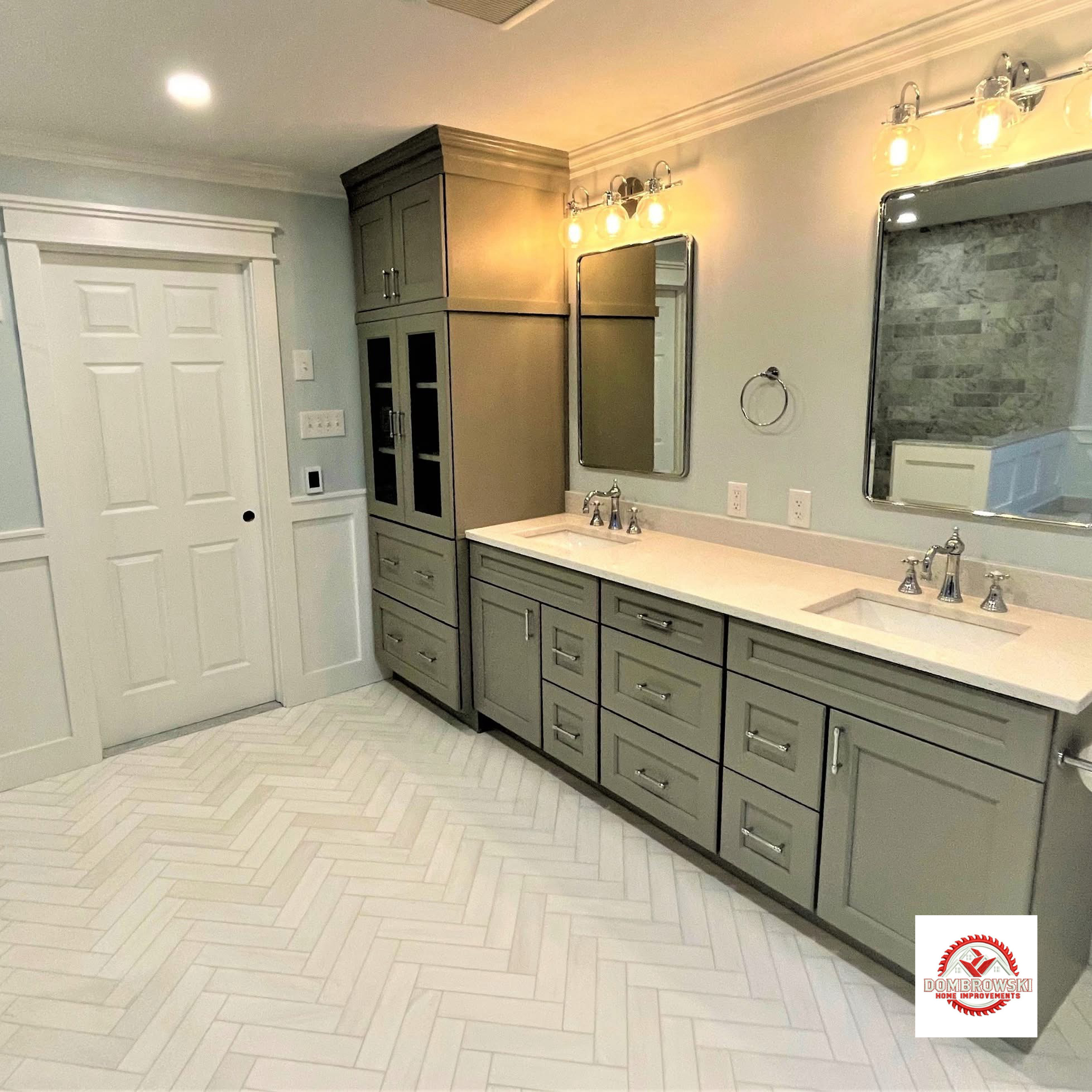 Large double gray vanity with herringbone floor tile, chrome hardware and crown molding