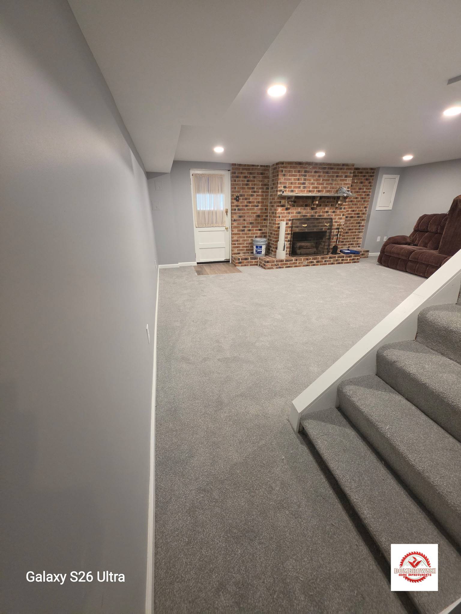 Finished basement with egress window and neutral walls in Bucks County, PA by Dombrowski Home Improvements