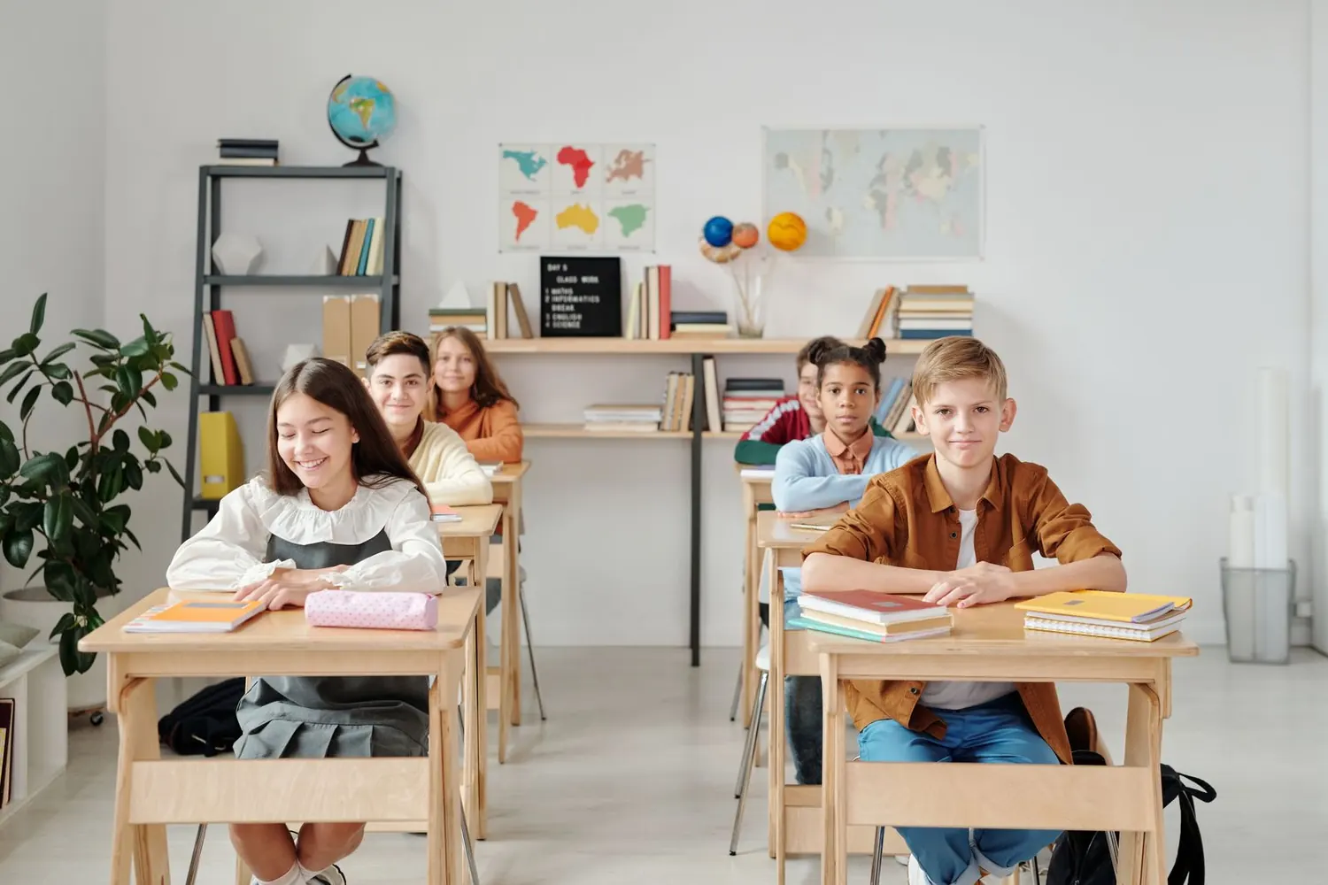 Smiling children seated at desks in a bright modern classroom