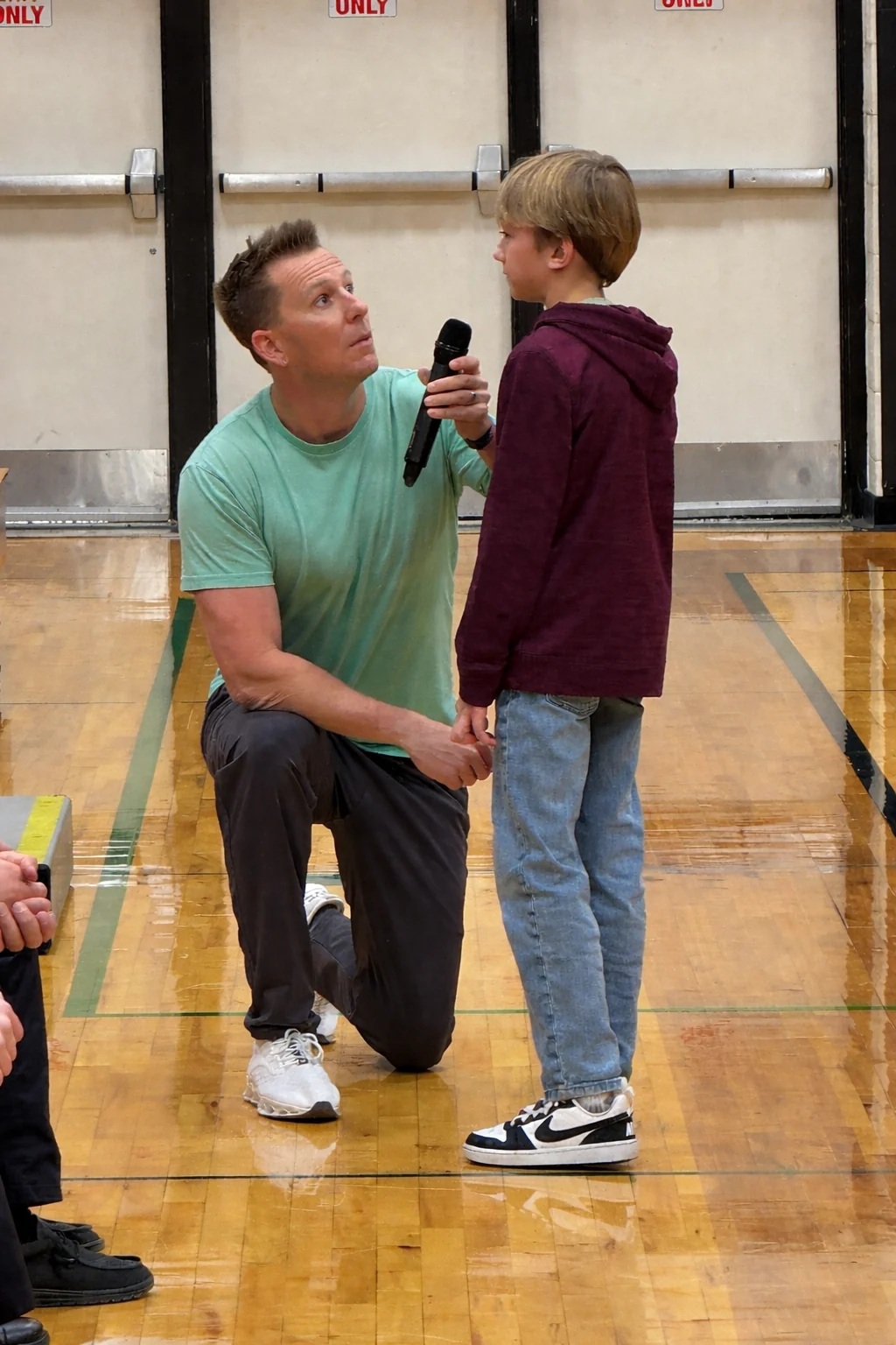Nick listening at eye level during a conversation with an athlete