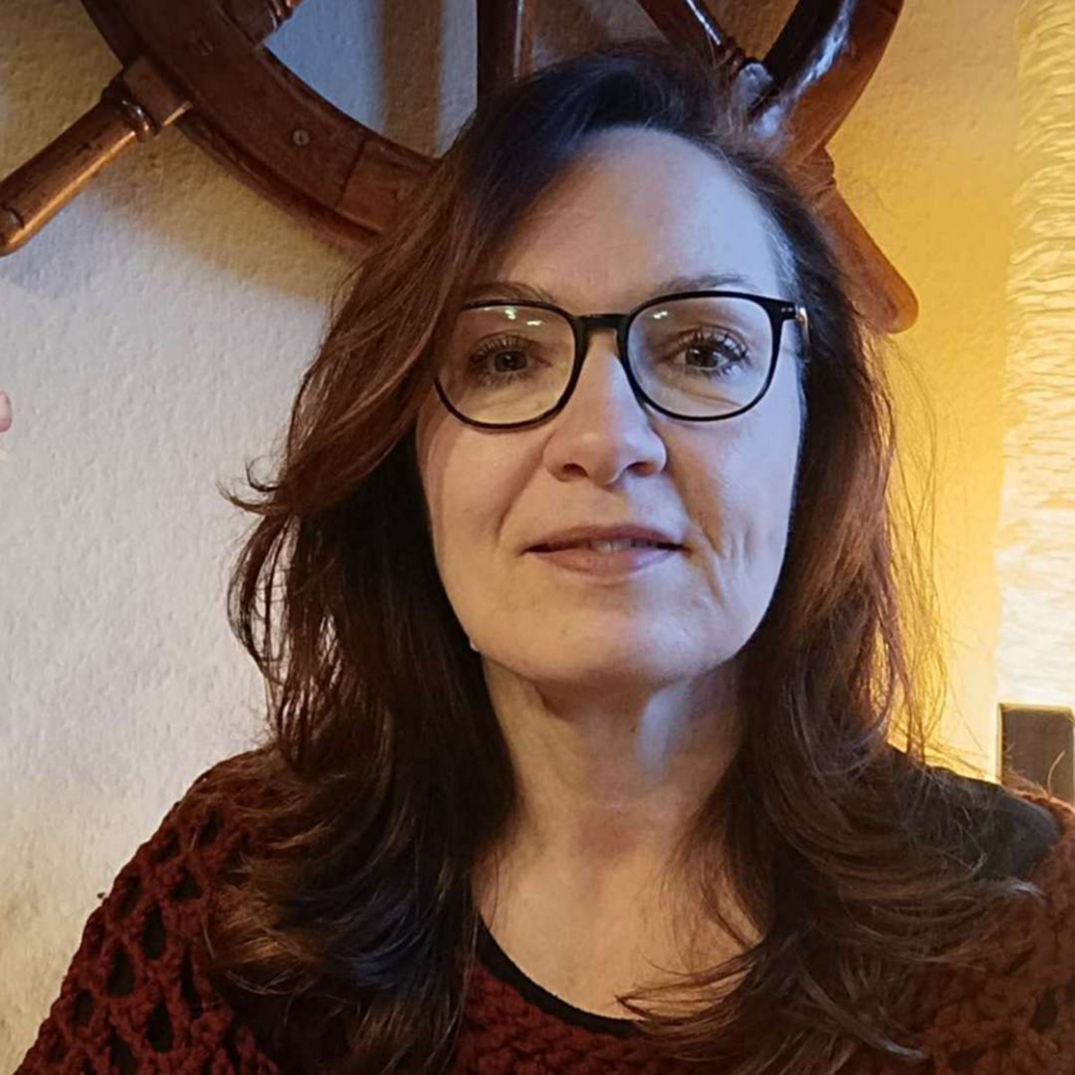 Katja sitzt an ihrem Schreibtisch mit Zeichentablet und Hoptimist, lächelt in die Kamera – offen für kreative Ideen und echte Verbindung.