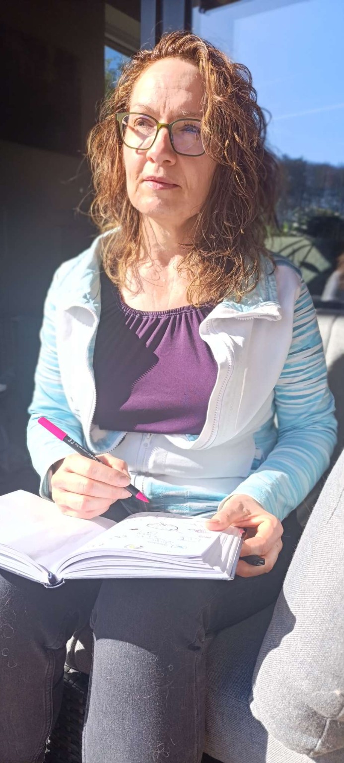 Katja Schoonbergen sitzt in der Sonne und schreibt in ein Journal – achtsame Reflektion und persönlicher Prozess. Katja Schoonbergen sitzt in der Sonne und schreibt in ein Journal – achtsame Reflektion und persönlicher Prozess.
