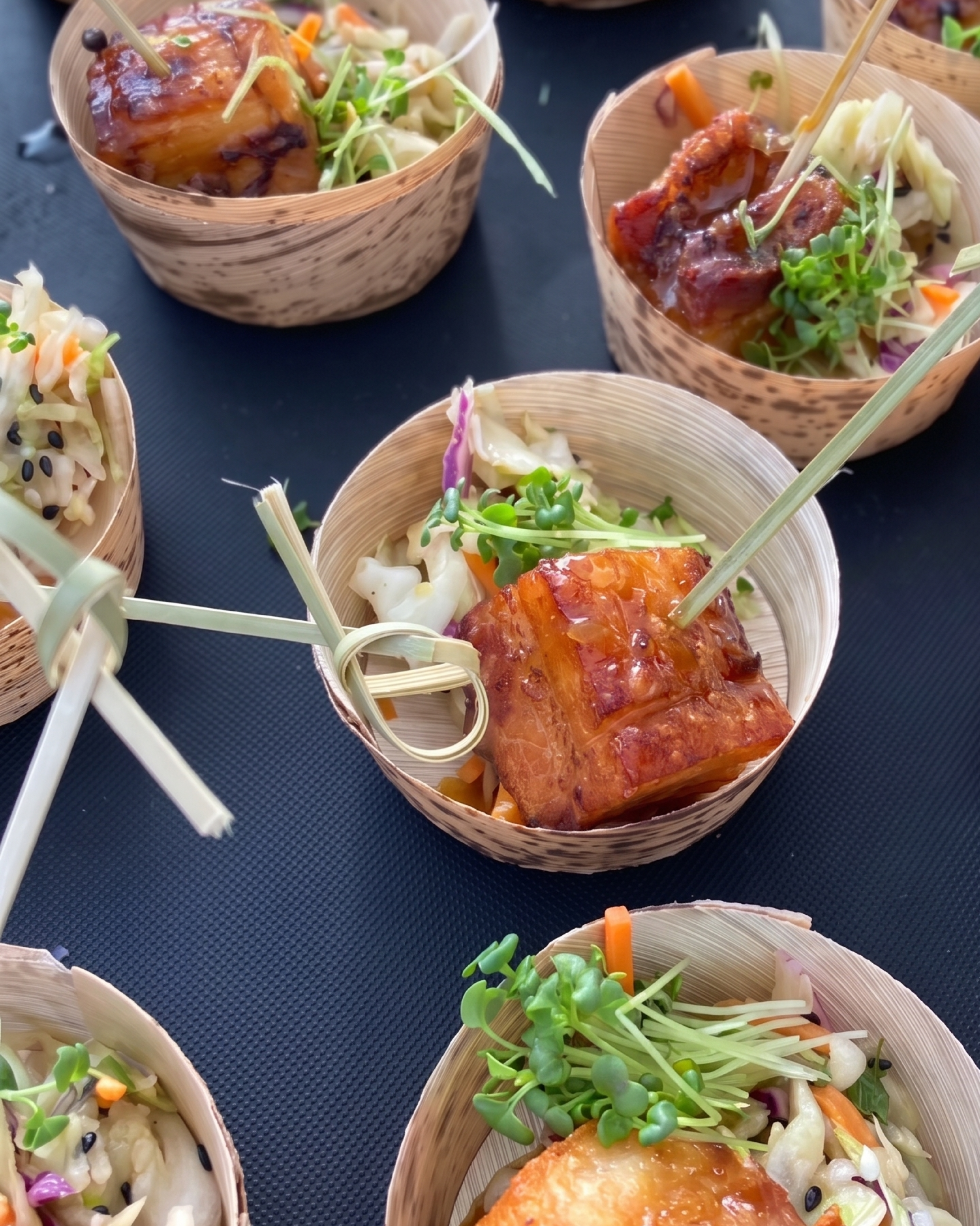 Gourmet glazed pork belly bites served in eco-friendly bamboo bowls, perfect for passed appetizers at a cocktail party or wedding reception in South Portland.