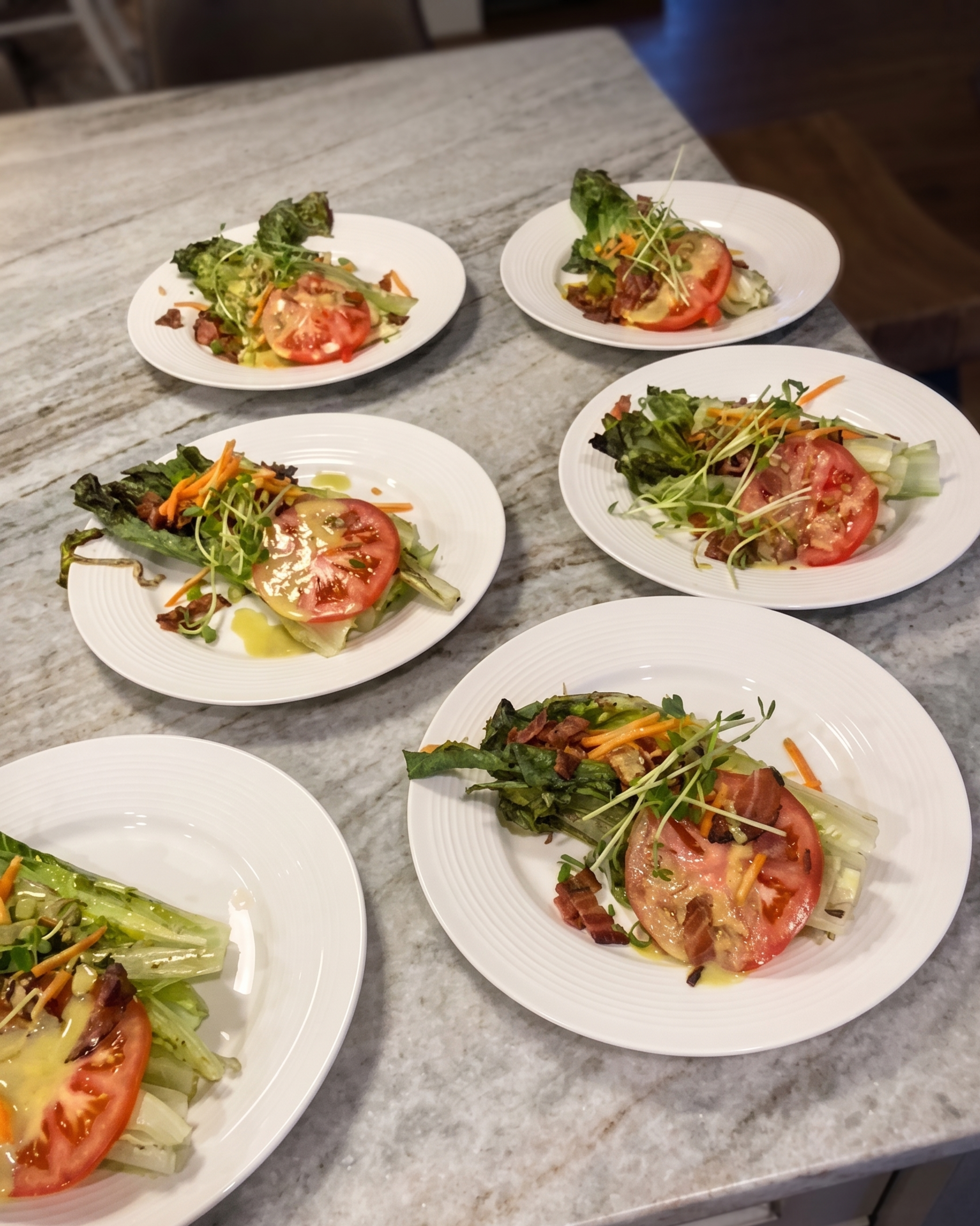 Six freshly prepared gourmet salads with heirloom tomatoes and microgreens, plated by Grateful Culinary Collaborations for a private event in Southern Maine.