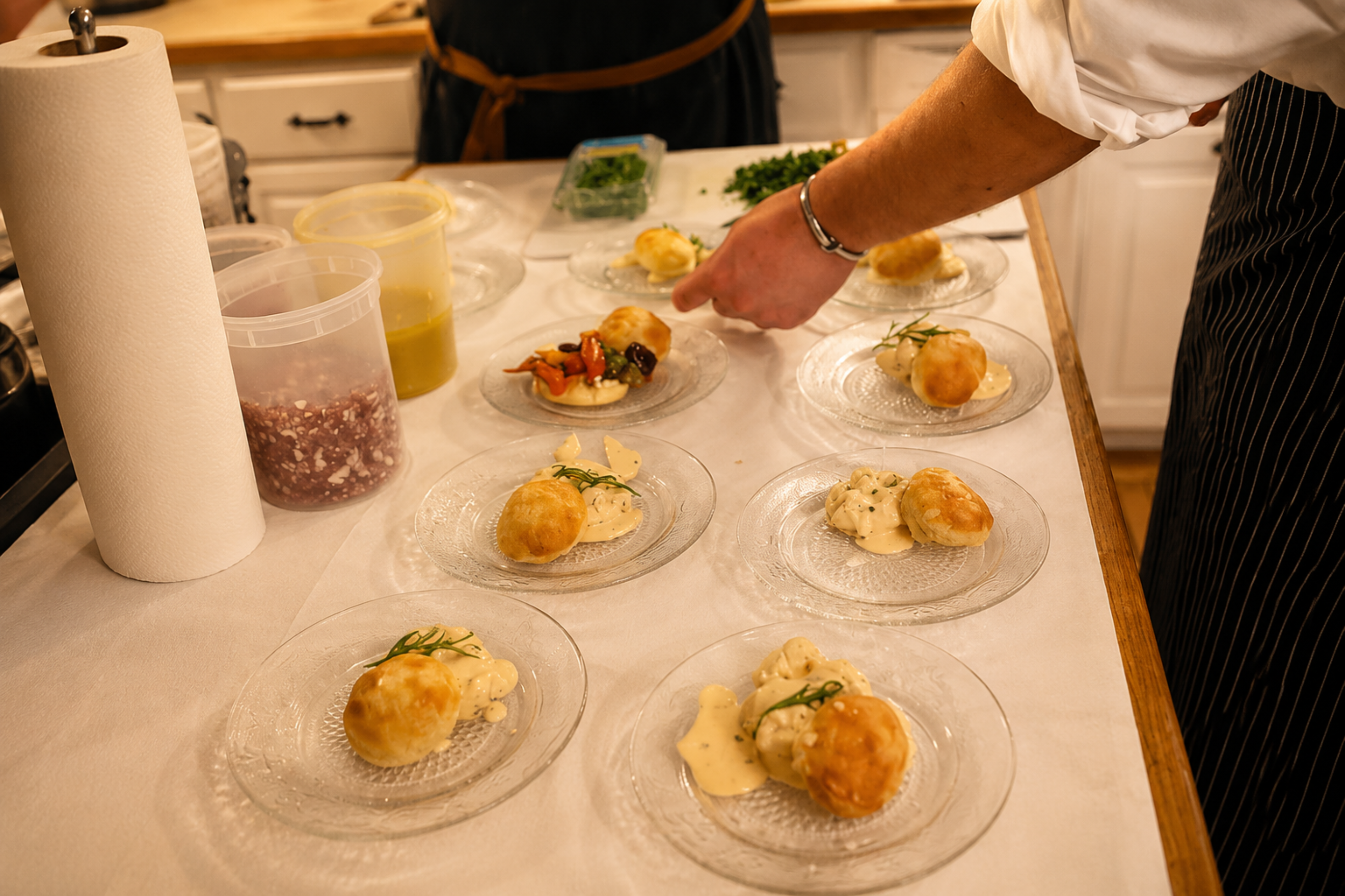 A professional private chef carefully plating an interactive, multi-course meal during a chef-guided culinary experience.