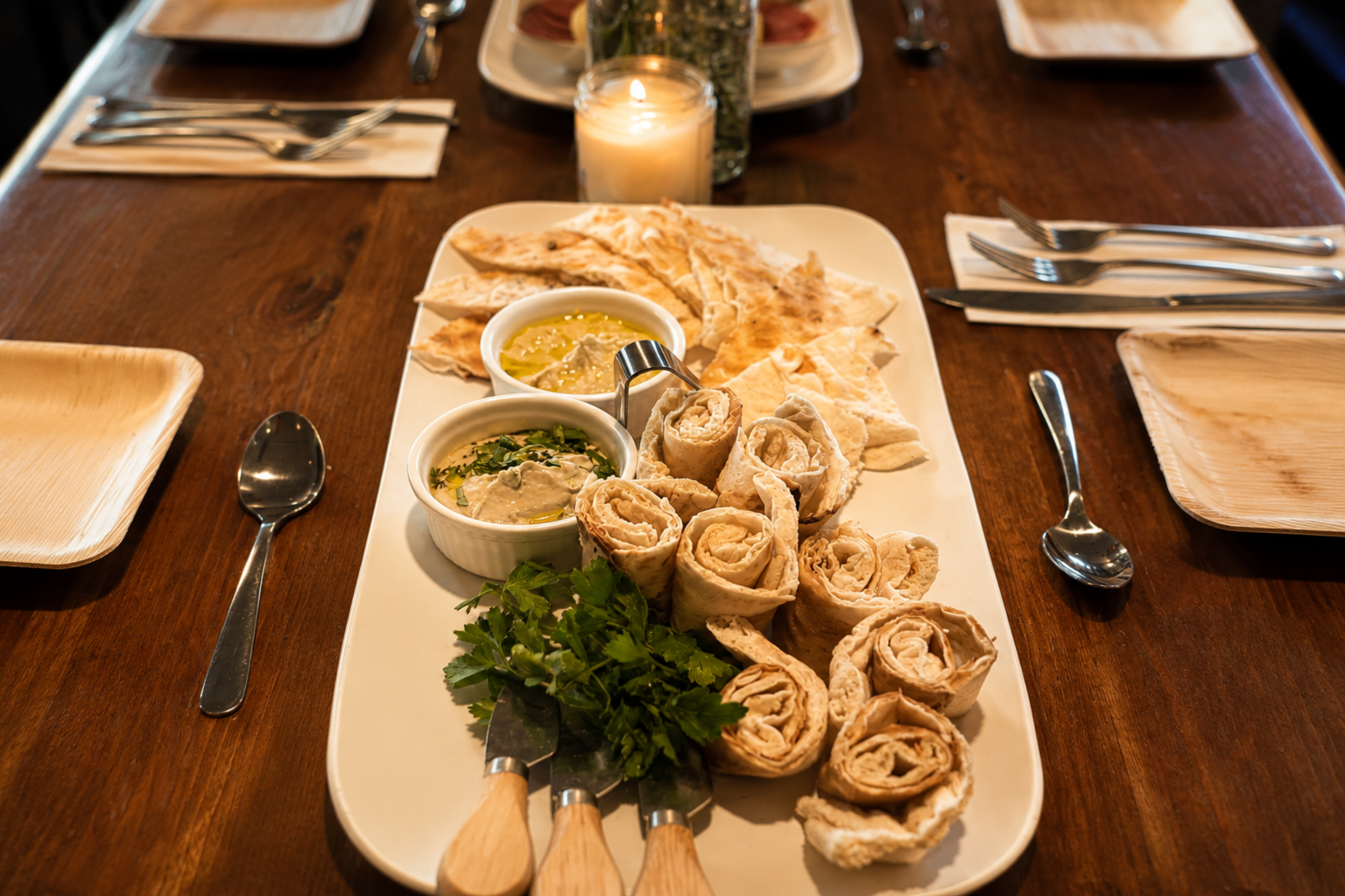 An appetizing flatbread and hummus dip platter served at a dining table, showcasing customized private chef menus tailored to dietary preferences.